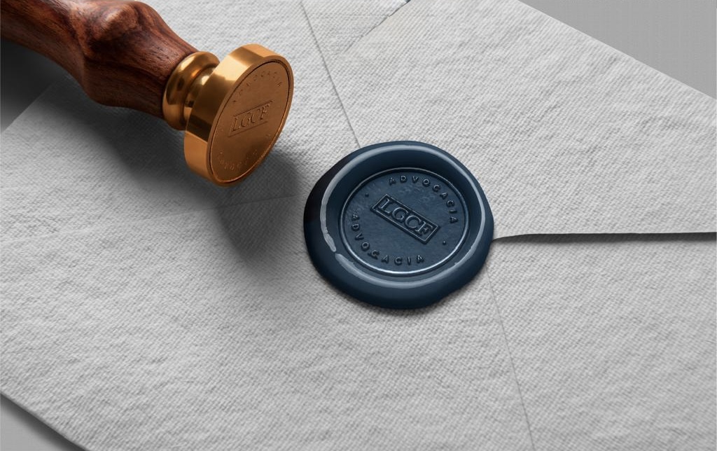 Selo de cera azul com o monograma LGCF Advocacia sobre papel texturizado